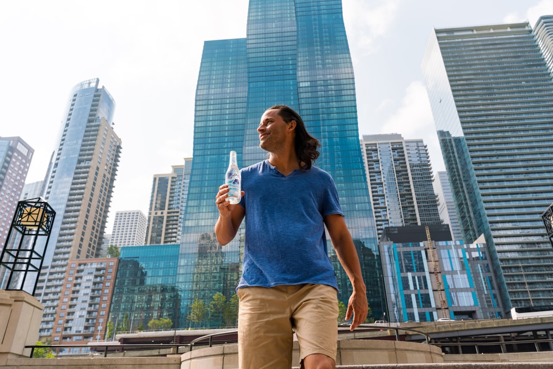 person adding electrolyte packet to water bottle outdoors